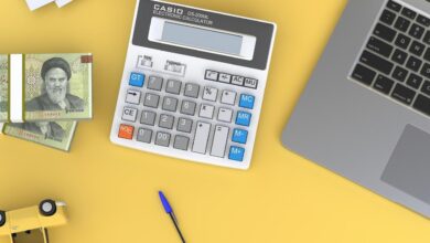 a calculator sitting on top of a desk next to a laptop
