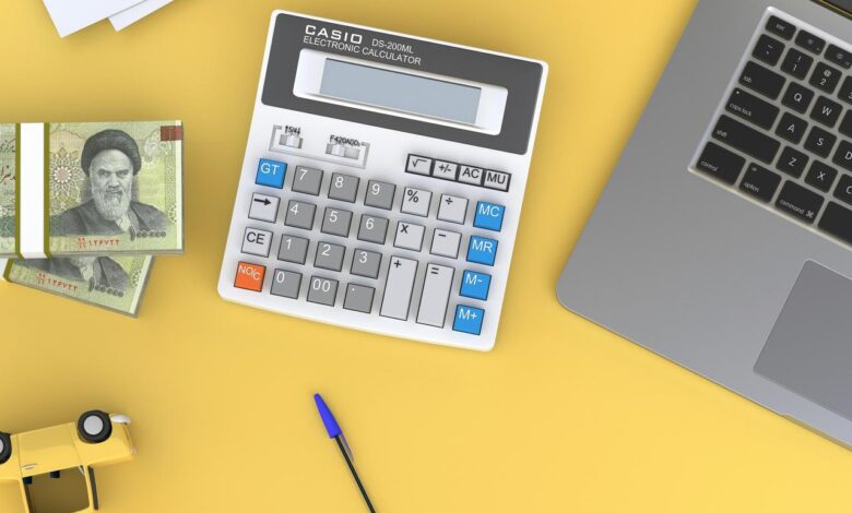 a calculator sitting on top of a desk next to a laptop