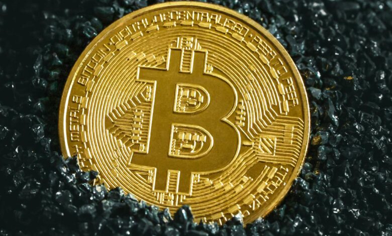a bitcoin sitting on top of a black surface